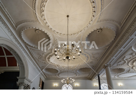 Architecture splendour interior of The Church of King Charles the Martyr with chandelier hanging on ceiling are made of plaster with five domes. Architecture splendour interior of The Church of King Charles the Martyr with chandelier hanging on ceiling are made of plaster with five domes. 134159584