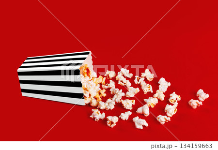 box with popcorn striped in different colors on a red background 134159663
