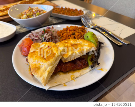 Traditional meal with kebab and bulgur. Turkish cuisine. Food culture, dining, cuisine, appetite, lunch flavor and restaurant serving experience. Traditional meal with kebab and bulgur. Turkish cuisine. Food culture, dining, cuisine, appetite, lunch flavor and restaurant serving experience. 134160511