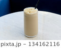Tall glass of iced latte with almond flakes 134162116