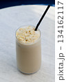 Tall glass of iced latte with almond flakes 134162117