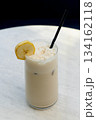 Tall glass of iced latte with almond flakes 134162118