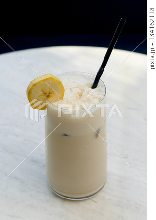Tall glass of iced latte with almond flakes Tall glass of iced latte with almond flakes 134162118