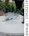 Table setting for a wine party with bottles and empty drink glasses 134162119