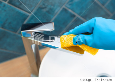 Person is cleaning a sink faucet, cleaning service Person is cleaning a sink faucet, cleaning service 134162586