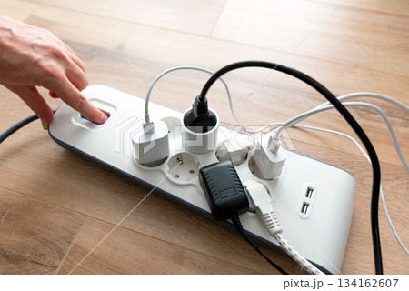 Person is plugging in a device to a power strip Person is plugging in a device to a power strip 134162607