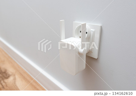 Wireless Wi-Fi repeater on white wall indoors 134162610