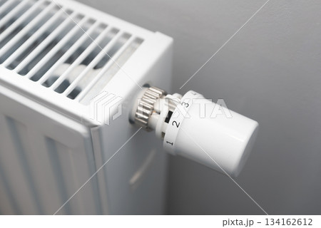 Person is adjusting the temperature on a radiator Person is adjusting the temperature on a radiator 134162612