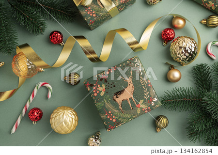 Christmas Gift Wrapping Flatlay with Ornaments and Tags on Green Background 134162854