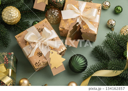 Christmas Gifts with Ornaments and Evergreen Branches on Festive Background Christmas Gifts with Ornaments and Evergreen Branches on Festive Background 134162857