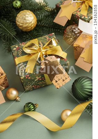 Christmas Gifts with Ornaments and Evergreen Branches on Festive Background Christmas Gifts with Ornaments and Evergreen Branches on Festive Background 134162858
