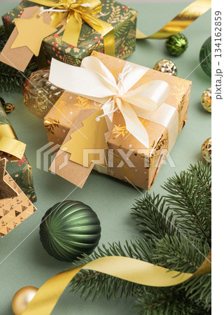 Christmas Gifts with Ornaments and Evergreen Branches on Festive Background Christmas Gifts with Ornaments and Evergreen Branches on Festive Background 134162859