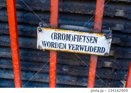 Dutch language Warning sign Mopeds will be removed - translation. Bicycle parking prohibited. Old metal sign. Amsterdam street Netherlands Dutch language Warning sign Mopeds will be removed - translation. Bicycle parking prohibited. Old metal sign. Amsterdam street Netherlands 134162909