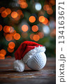 Holiday decor: golf ball with santa hat on blurred christmas lights background. Vertical banner. Copy space. White golf ball decorated with santa hat, blurred background. For golf club, sports store 134163671