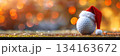 Christmas golf ball with santa hat on blurred holiday background for seasonal design. Horizontal banner. Copy space. White golf ball decorated with santa hat. For golf club, sports store 134163672