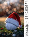 Festive golf ball with santa hat on green grass in blurred christmas lights background for holiday decor. Vertical banner. Copy space. Close-up. For golf club, sports store 134163674