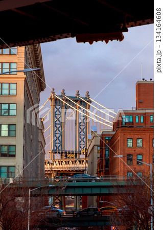 Manhattan Bridge from street in Brooklyn with buildings lining the scene 134164608