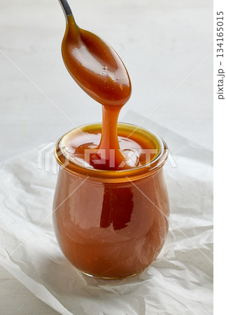 freshly cooked homemade caramel sauce pouring in jar freshly cooked homemade caramel sauce pouring in jar 134165015