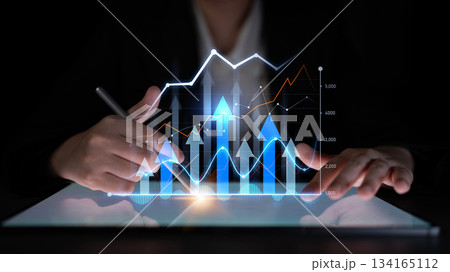 Business professional analyzing financial growth trends with advanced technology graphics and data visualization on a digital tablet in a dark environment Scalp Business professional analyzing financial growth trends with advanced technology graphics and data visualization on a digital tablet in a dark environment Scalp 134165112