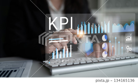 Business Professional Using Innovative Technology to Analyze Key Performance Indicators on a Laptop with Digital Graphs and Charts Displayed on Screen Gantry 134165136