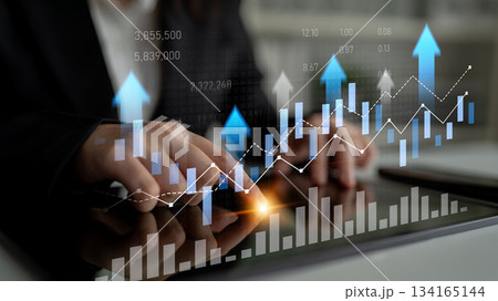 Professional hands engaging with data visualization on tablet device, representing growth, finance trends, and market analytics in dynamic business environment Scalp 134165144