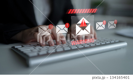 Warning notification on a laptop screen indicating potential email threats with hands typing on a keyboard in a blurred background Gantry Warning notification on a laptop screen indicating potential email threats with hands typing on a keyboard in a blurred background Gantry 134165401