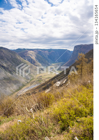 Top view of mountain road leading to Katu Yaryk pass and Chulyshman valley with river in Altai Russia Dramatic highland landscape with winding route and deep canyon Top view of mountain road leading to Katu Yaryk pass and Chulyshman valley with river in Altai Russia Dramatic highland landscape with winding route and deep canyon 134165654