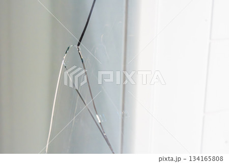 Large crack across a triple glazed window in a residential apartment. Indicates potential structural issues, thermal stress or manufacturing defect during construction. Large crack across a triple glazed window in a residential apartment. Indicates potential structural issues, thermal stress or manufacturing defect during construction. 134165808