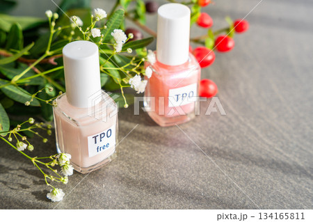 Two gel nail polish bottles labeled TPO and TPO Free on a table with flowers. Concept of chemical awareness and safe beauty products without Trimethylbenzoyl Diphenylphosphine Oxide Two gel nail polish bottles labeled TPO and TPO Free on a table with flowers. Concept of chemical awareness and safe beauty products without Trimethylbenzoyl Diphenylphosphine Oxide 134165811
