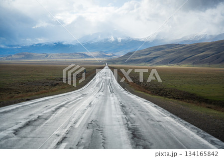 Mountain road and valley of Chuysky Trakt Altai Russia. Scenic route through rugged terrain and expansive natural landscape Mountain road and valley of Chuysky Trakt Altai Russia. Scenic route through rugged terrain and expansive natural landscape 134165842