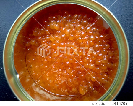 Red Salmon Caviar in a Clear Jar Sitting on a Dark Surface in a Kitchen Setting 134167053