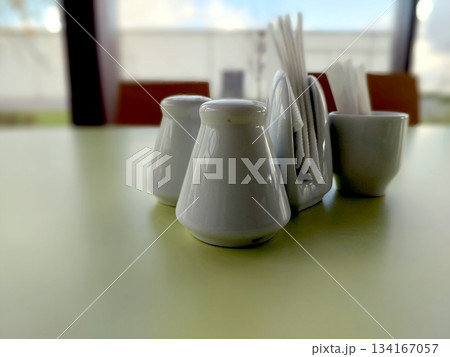 Salt and Pepper Shakers With Napkins and Cutlery on the Table at a Casual Dining Area Salt and Pepper Shakers With Napkins and Cutlery on the Table at a Casual Dining Area 134167057
