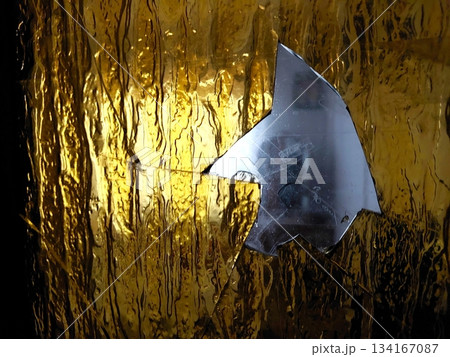 Glass From a Broken Door Reflects Light in a Dim Indoor Space During the Evening Hours Glass From a Broken Door Reflects Light in a Dim Indoor Space During the Evening Hours 134167087