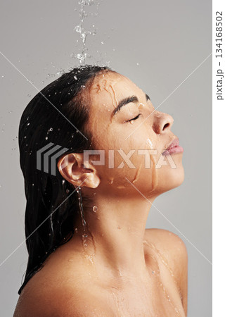 Shower, washing and face of woman with water in studio on grey background for wellness, cleaning and grooming. Hair care, bathroom and female person with beauty for hygiene, satisfaction and health Shower, washing and face of woman with water in studio on grey background for wellness, cleaning and grooming. Hair care, bathroom and female person with beauty for hygiene, satisfaction and health 134168502