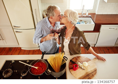 Kiss, wine toast or old couple cooking food for a healthy vegan diet together with love in retirement at home. Top view of senior woman drinking or kissing in kitchen with mature husband at dinner 134168757