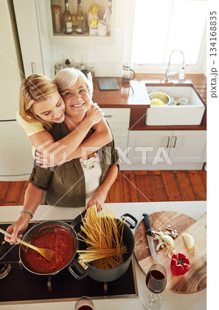 Hug, woman or portrait of happy mother cooking food in healthy diet meal together with love at home. Family, embrace or adult child hugging or helping senior mom in house kitchen for lunch or dinner Hug, woman or portrait of happy mother cooking food in healthy diet meal together with love at home. Family, embrace or adult child hugging or helping senior mom in house kitchen for lunch or dinner 134168835