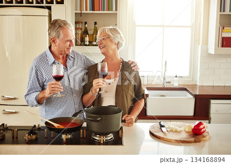 Love, wine or happy old couple cooking food for a healthy diet together with love in retirement at home. Hugging or happy senior woman laughing or drinking in kitchen with mature husband at dinner 134168894