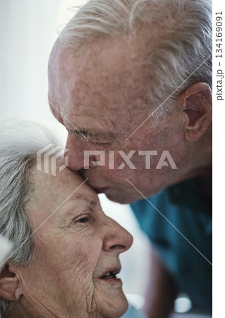 Elderly, kiss and couple in hospital for healthcare, visiting sick patient and hope for recovery. Clinic, senior man and woman kissing on forehead with love, care and empathy, kindness and comfort. 134169091