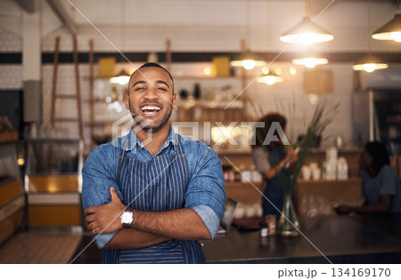 Coffee shop, waiter and portrait of black man laugh in restaurant for cafe service, working and crossed arms. Small business owner, bistro startup and happy male barista in cafeteria ready to serve 134169170