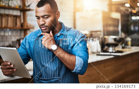 Focus, tablet and thinking with man in cafe for online, entrepreneurship and startup. Retail, technology and food industry with small business owner in restaurant for barista, store and coffee shop 134169173