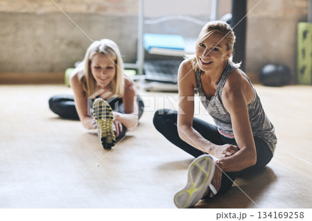 Portrait, smile and women on the floor, stretching and energy with confidence, workout goals and training. Female person, friends and girls in a gym, stretch legs and exercise with balance and health 134169258