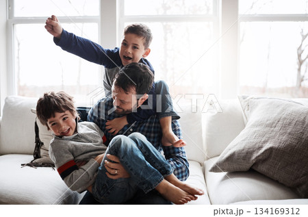 Dad with boy children, playing and energy with fun, carefree with love and laughter at family home. Man play with kids laughing in living room, crazy and playful with piggyback, hug and excited 134169312