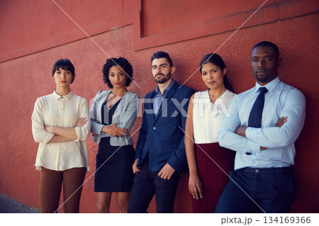 Portrait, business people and diversity of serious team, professional commitment and collaboration against a red wall. Focused group of confident employees with corporate pride, trust and solidarity 134169366