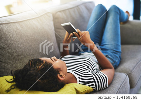 Relax, phone and woman laying on sofa in home for network, online website and social media. Communication, mobile app and happy female person on smartphone for chatting, text message and internet 134169569