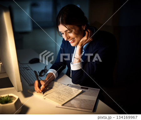 Book, smile and businesswoman or writing at night or planning and pc in an office. Corporate, dark and female worker or project manager in the evening or company note and dedicated on computer 134169967