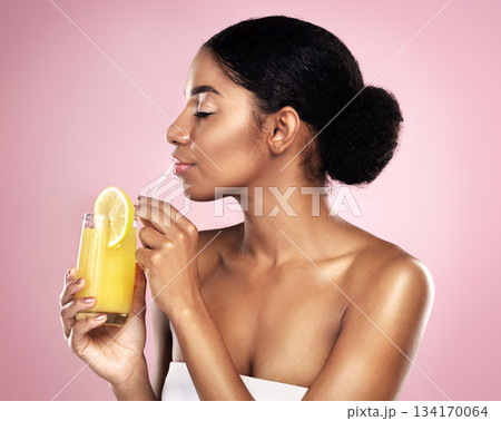 Face of woman, orange juice and drink in studio, pink background and detox for healthy skincare. African model, citrus smoothie and vitamin c fruits for nutrition benefits, natural beauty or wellness Face of woman, orange juice and drink in studio, pink background and detox for healthy skincare. African model, citrus smoothie and vitamin c fruits for nutrition benefits, natural beauty or wellness 134170064
