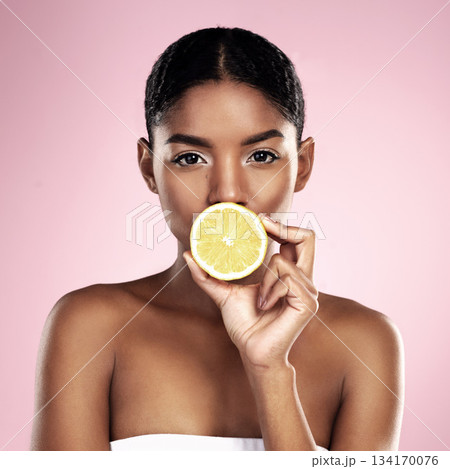 Portrait, woman and lemon for beauty in studio, pink background and wellness of vitamin c cosmetics. Face of african model, citrus fruits and nutrition for skincare, organic benefits and natural diet 134170076