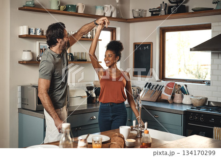 Interracial couple, dance and love in kitchen for romance, fun bonding or holiday together at home. Happy man and woman dancing in joyful happiness for romantic relationship or enjoying weekend house Interracial couple, dance and love in kitchen for romance, fun bonding or holiday together at home. Happy man and woman dancing in joyful happiness for romantic relationship or enjoying weekend house 134170299