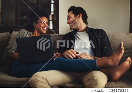 Laptop, relax and an interracial couple streaming a movie using an online subscription service for entertainment. Computer, watching or internet with a man and woman bonding together over a video Laptop, relax and an interracial couple streaming a movie using an online subscription service for entertainment. Computer, watching or internet with a man and woman bonding together over a video 134170321