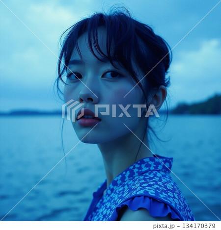 AI generated Poignant image of contemplative lady gazing across tranquil sea at dusk 134170379